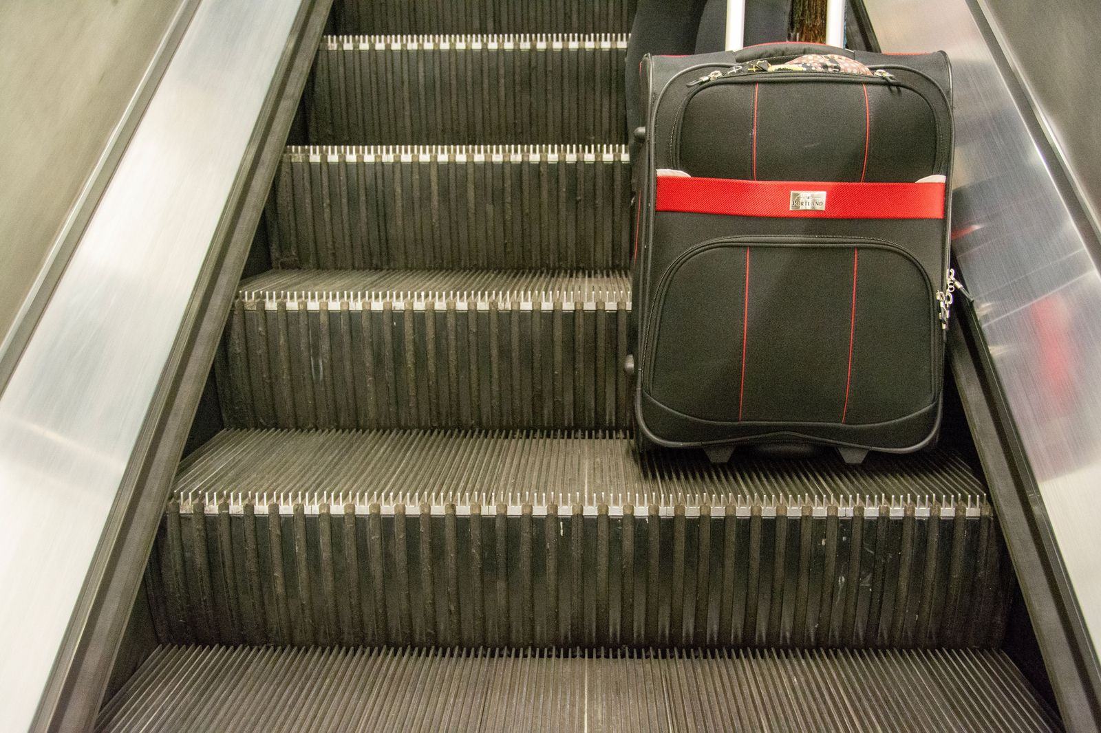 The single carousel: bags in ten minutes, the chauffeur beside it with your name